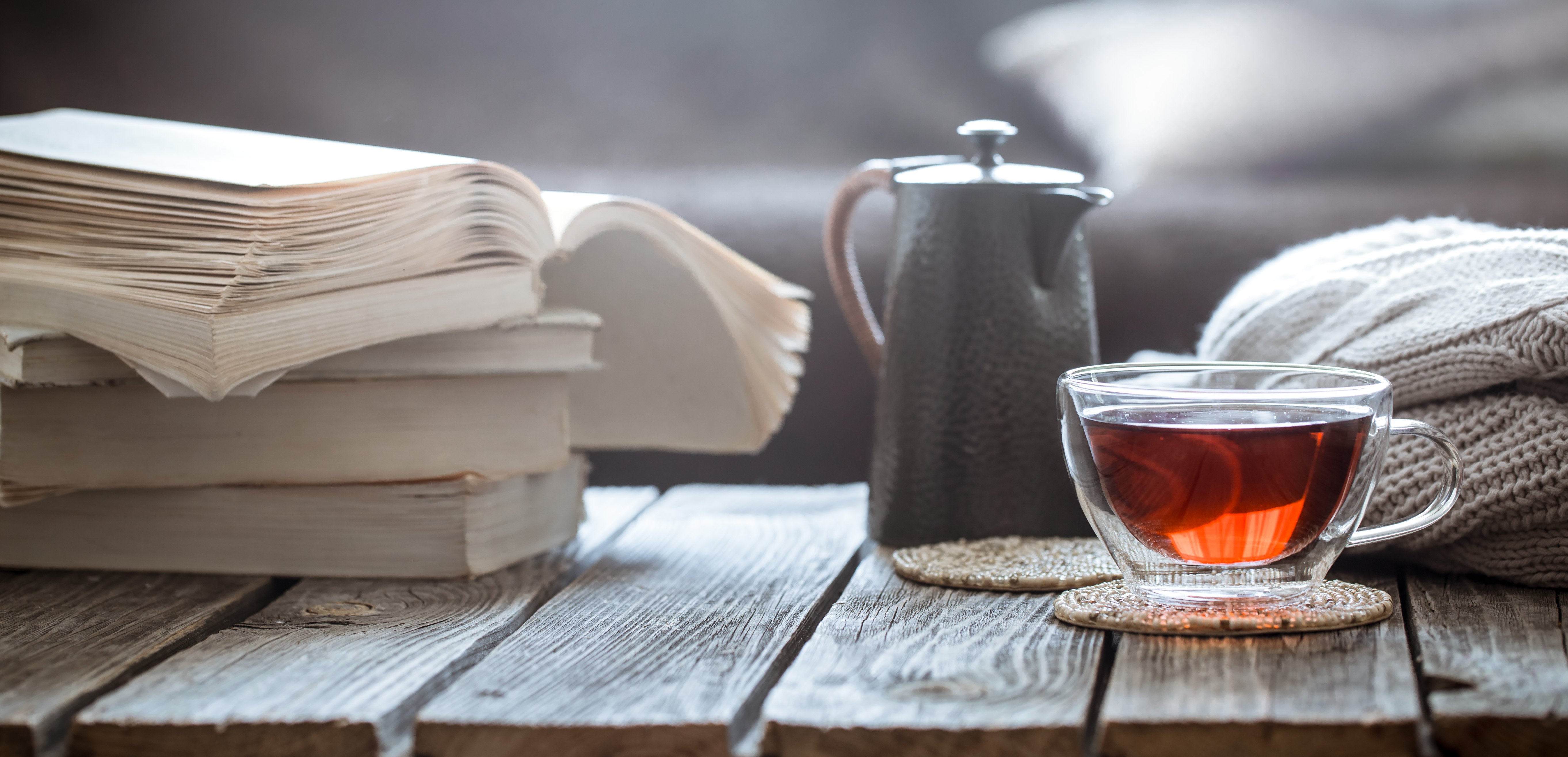 still life book and a cup of tea in the living room on a wooden table, the concept of coziness and interior