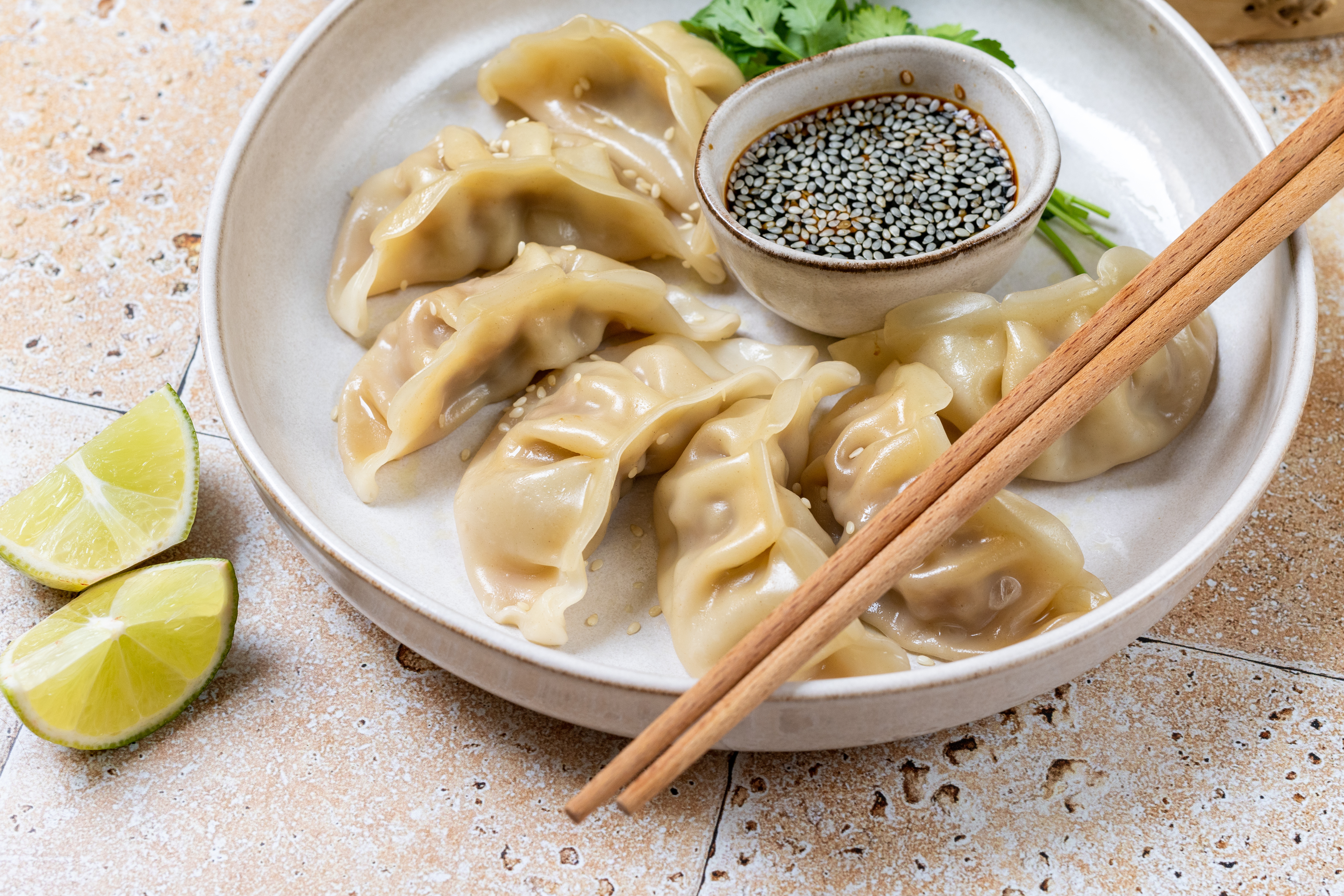 Dumplings gyoza jiaozi steamed  on a white plate with soy sauce.